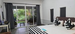 a bedroom with a bed and a large window at Villa The Leaf in Weligama