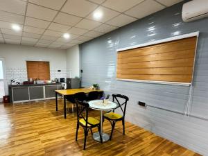 a room with a table and chairs and a kitchen at QUDWAHSTAY in Kota