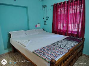 a bed in a room with a red window at D'Souza Home stay in Māvalli