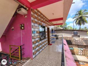 a pink wall of a building with a balcony at D'Souza Home stay in Māvalli