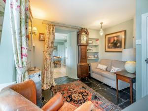 a living room with a couch and a grandfather clock at Howe Cottage in Bowness-on-Windermere