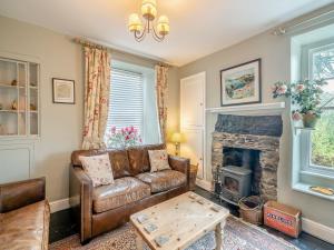 a living room with a couch and a fireplace at Howe Cottage in Bowness-on-Windermere