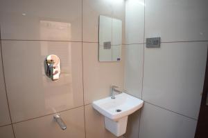 a white bathroom with a sink and a mirror at Pearl Suites in Cochin