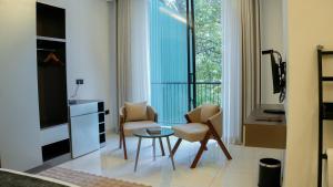 a living room with two chairs and a table and a tv at Orbit88 Hotel by AMR in Kandy