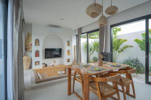 a dining room with a table and chairs at Monstera Uluwatu in Uluwatu