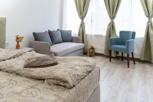 ein Schlafzimmer mit einem Bett, einer Couch und einem Stuhl in der Unterkunft Стаи Симида in Debnevo
