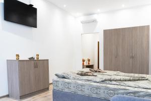 ein Schlafzimmer mit einem Bett und einem Fernseher an der Wand in der Unterkunft Стаи Симида in Debnevo