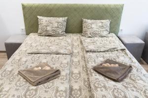 ein Bett mit zwei Kissen und zwei Handtüchern darauf in der Unterkunft Стаи Симида in Debnevo