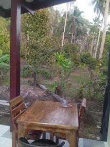 a wooden table and chairs on a porch at Chom Suan Farmstay in Ko Kood