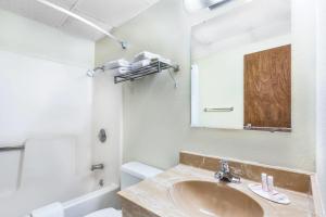 a bathroom with a sink and a toilet and a mirror at Days Inn by Wyndham Warrensburg in Warrensburg +38 photos