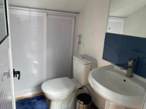 a bathroom with a white toilet and a sink at Villa Capri first floor in Quatre Bornes