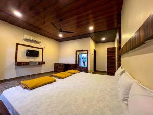 a large bedroom with a large bed with yellow pillows at Suryavan Holidays in Chinchavli