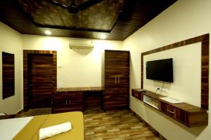 a room with a bed and a television in it at Suryavan Holidays in Chinchavli