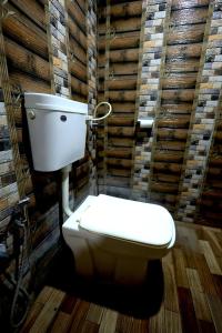 a toilet in a bathroom with a wooden wall at Suryavan Holidays in Chinchavli +32 photos