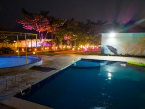 a swimming pool at night with lights at Suryavan Holidays in Chinchavli