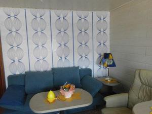 a living room with a blue couch and a table at Ferienwohnung Anneli Edert in Bad Harzburg