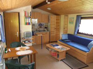 a living room with a blue couch and a kitchen at Ferienhaus Walnuss-Hütte in Bad Harzburg