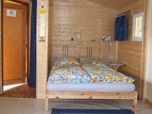 a bed in a wooden room with a wooden wall at Ferienhaus Walnuss-Hütte in Bad Harzburg