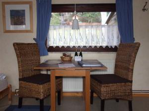a dining room table with two chairs and a window at Ferienhaus Walnuss-Hütte in Bad Harzburg +2 photos