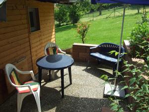 a patio with two chairs and a table and a bench at Ferienhaus Walnuss-Hütte in Bad Harzburg
