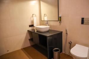 a bathroom with a sink and a toilet at River Deck Baga Beach Front in Calangute +31 photos