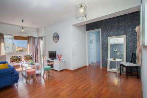 uma sala de estar com um sofá azul e pisos em madeira em Suite For You em Nicósia