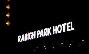 a sign for a raleigh park hotel at night at Rabigh Park Hotel in Rabigh