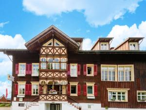 an old house with red shuttered windows at Holiday apartment in Bregenzerwald in Sibratsgfäll