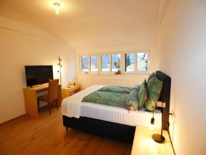 a bedroom with a bed and a desk and a television at Holiday apartment in Bregenzerwald in Sibratsgfäll
