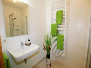 a white bathroom with a sink and a mirror at Holiday apartment in Bregenzerwald in Sibratsgfäll +19 photos