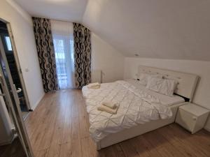 a bedroom with a bed with two towels on it at PENSIUNEA NASUI in Vişeu de Sus