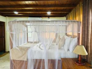a bedroom with a canopy bed with white pillows at Green Heaven Sigiriya in Sigiriya