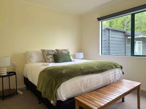 a bedroom with a large bed and a window at Peaceful Country Escape in Gordonton - Green Meadows Cottage in Taupiri
