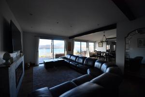 a living room with a leather couch and a television at Buckeye House by the lake in Yamanakako