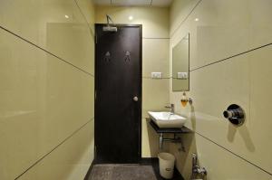 a bathroom with a black door and a sink at Hotel Magnum Inn in Junagadh