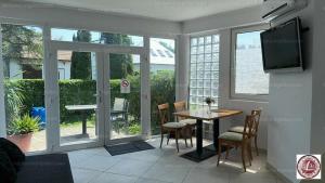 a dining room with a table and chairs and a television at Centrum Apartman in Balatonfenyves