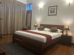a bedroom with a bed and two lamps and a window at Occazia Residence in Colombo