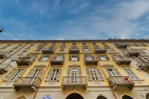 a yellow building with windows and balconies on it at Liberty Hotel in Turin