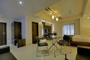 a room with a table and chairs and a bed at Hotel Magnum Inn in Junagadh +16 photos