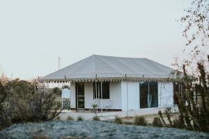 a white house with a tent in a field at Innara Hospitality in Mori Bera