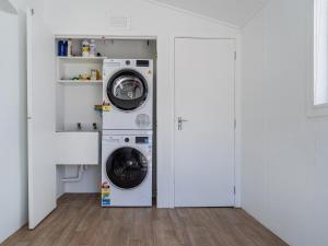 a laundry room with a washer and dryer at Beachfront Beauty - Whangamata Beachfront Home in Whangamata