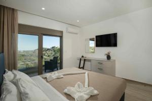 a bedroom with a large bed with a large window at Villa Kennedy in Faliraki