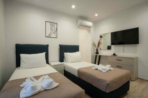 a hotel room with two beds and a television at Villa Kennedy in Faliraki +55 photos