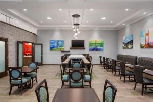 a waiting room with tables and chairs and a tv at Hampton Inn by Hilton Kamloops in Kamloops +27 photos