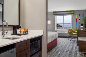 a hotel room with a sink and a bed at Hampton Inn by Hilton Kamloops in Kamloops