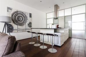 a living room with a kitchen with a counter and stools at Marnix Modern: Supercentral 8P in Amsterdam