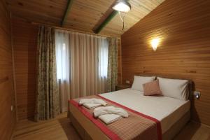 - une chambre avec un lit et des serviettes dans l'établissement Turnalı Bungalow, à Kıranköy