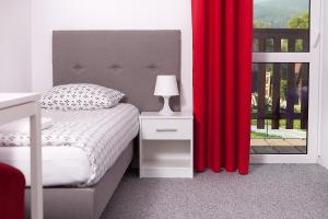 a bedroom with a bed and a red curtain at Villa Rosa in Stronie Śląskie +82 photos