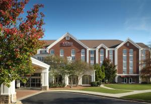 a large red brick building with a sign on it at Hilton Garden Inn Jackson-Madison in Madison
