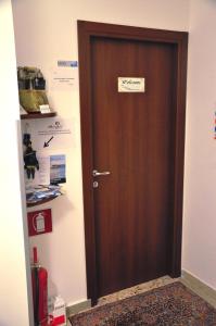 Una puerta de madera en una habitación con un cartel. en B&B MaryJosè, en Trapani